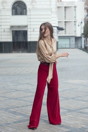 a woman in a brown shirt and red pants
