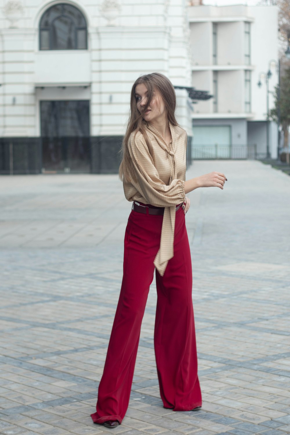 a woman in a brown shirt and red pants