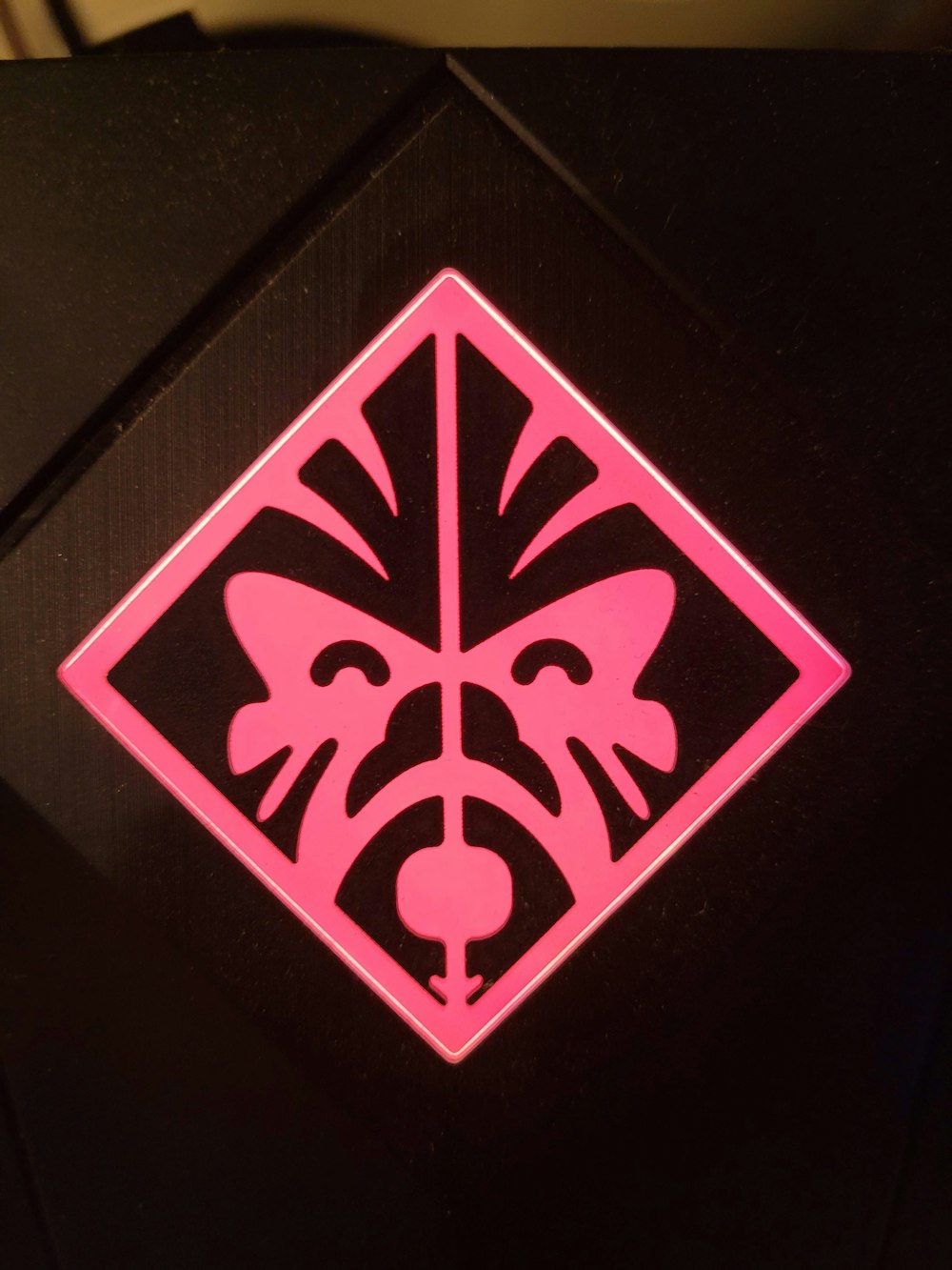 a close up of a pink and black sign