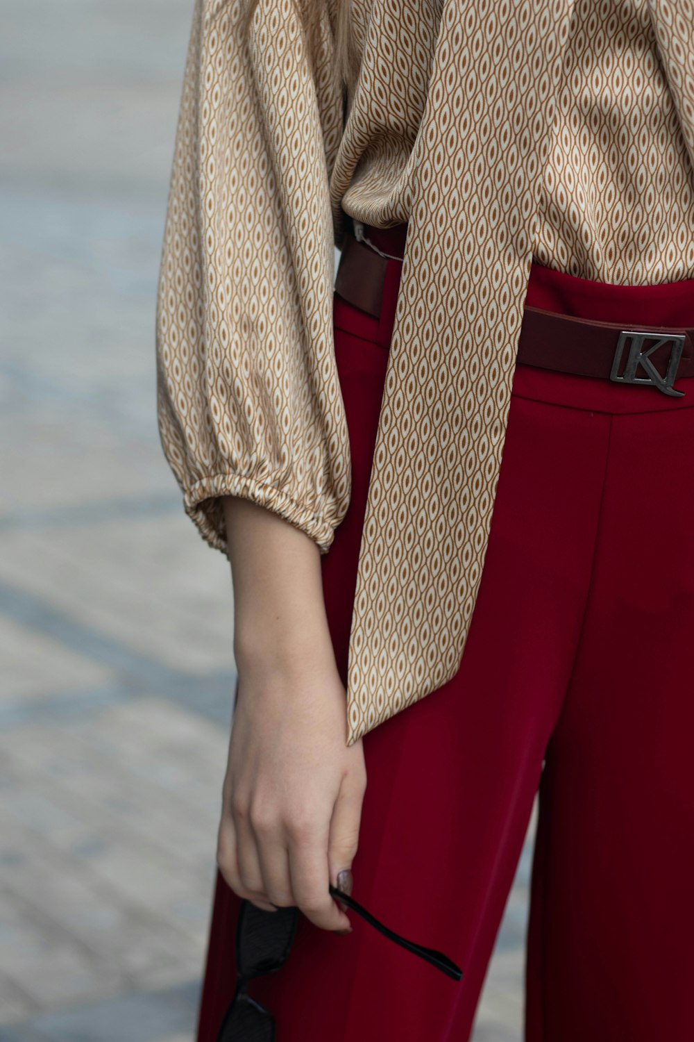 a woman wearing a brown shirt and red pants