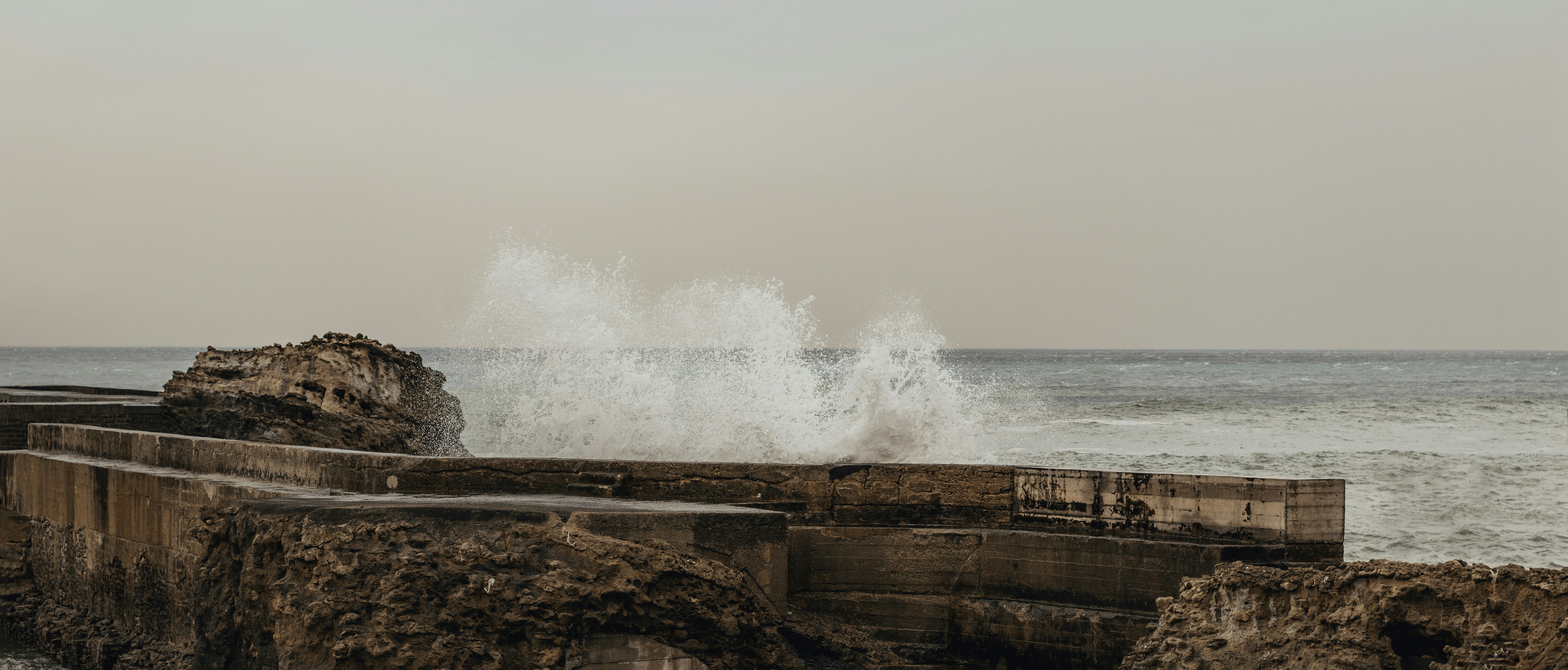 a large wave crashing into the shore of the ocean