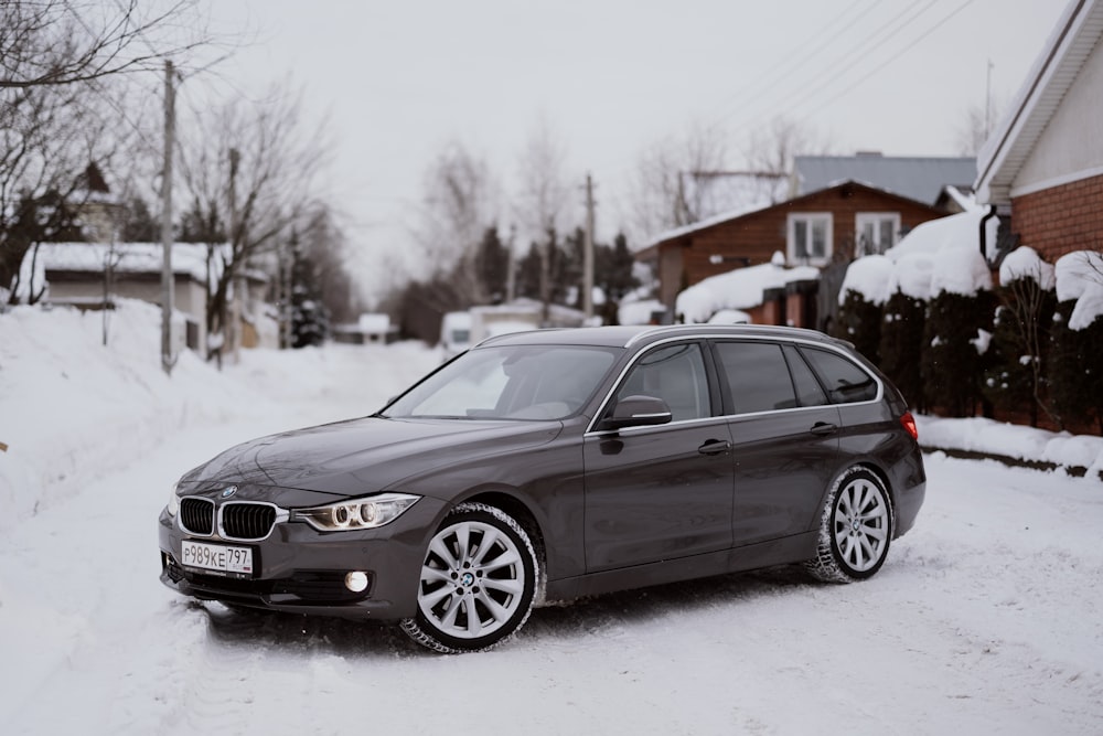 a grey car parked on a snowy street