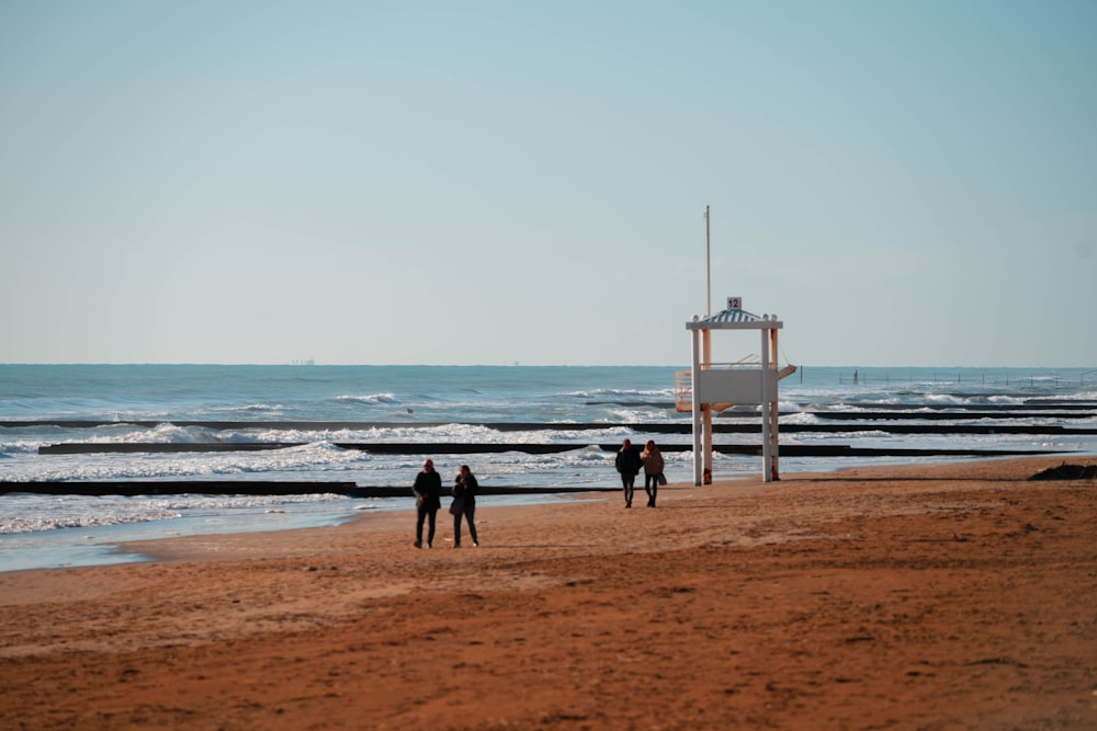 a group of people standing on top of a sandy beach