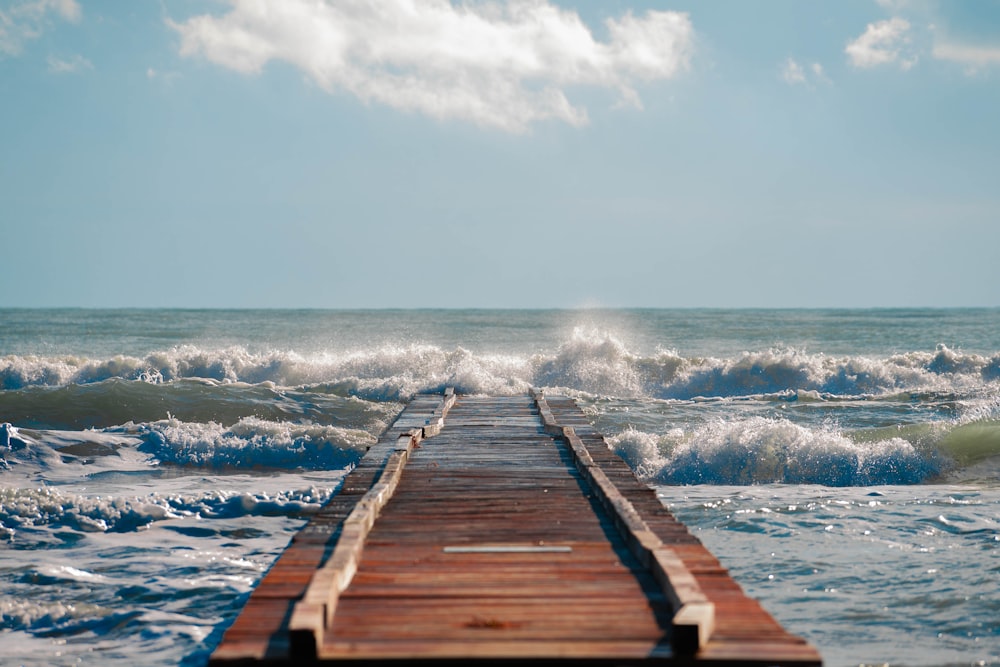 a long wooden pier extending into the ocean