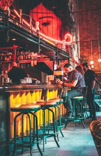 Sleek bar area with glowing electric purple underlighting and patrons chatting in stylish streetwear.
