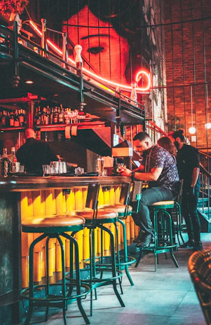 A stylish bar terrace at night with dim lights and colorful cocktails on the counter.
