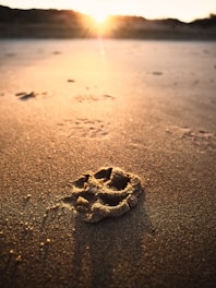 a smiley face drawn in the sand on a beach