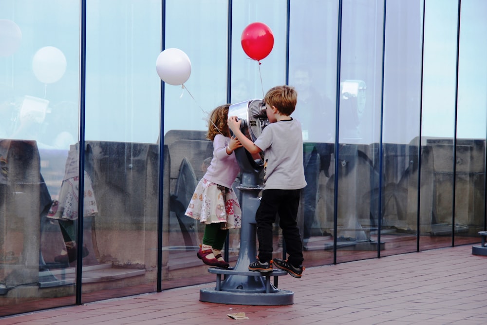 a couple of kids that are standing on a pole