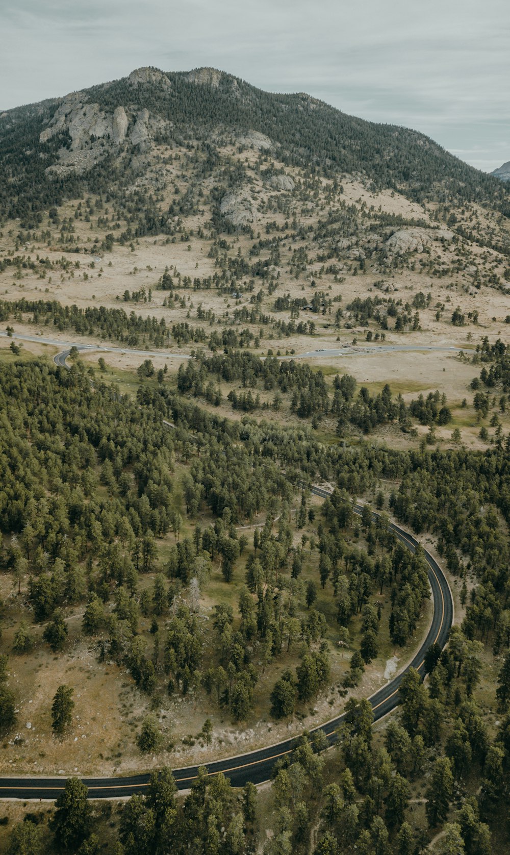 an aerial view of a winding road in the mountains