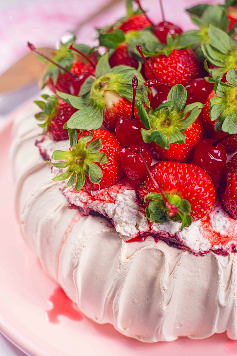 a cake covered in whipped cream and fresh strawberries