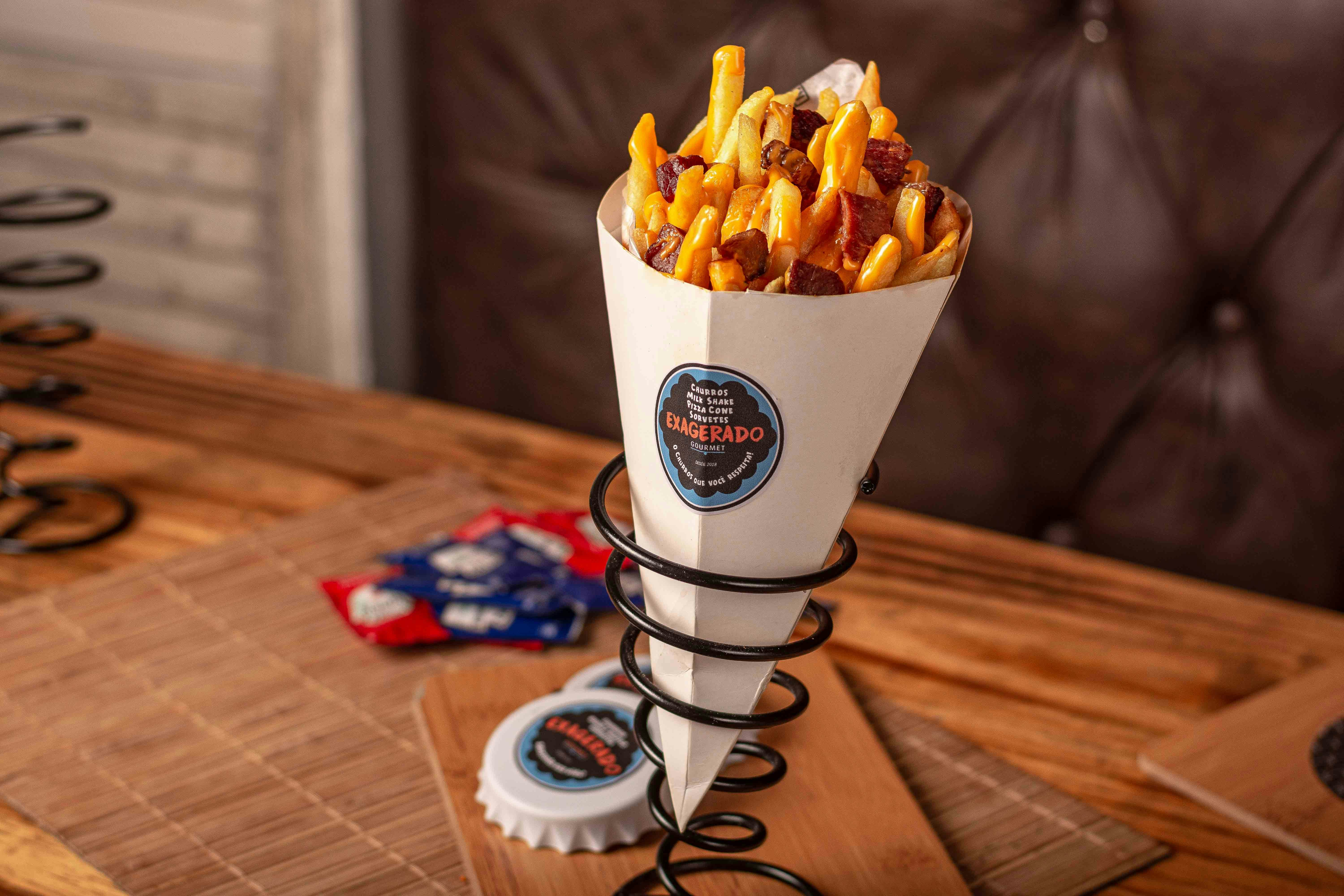 A paper cone of double-fried frites held in hand at a Brussels street friterie