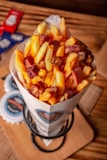 a bowl of fries sitting on top of a wooden table