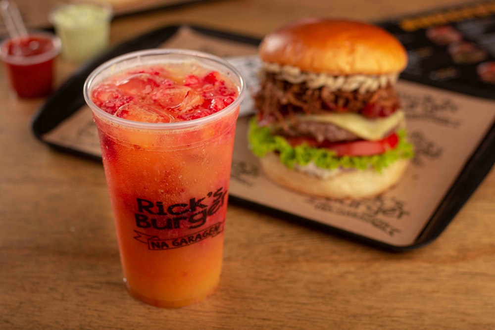 a hamburger and a drink sitting on a table