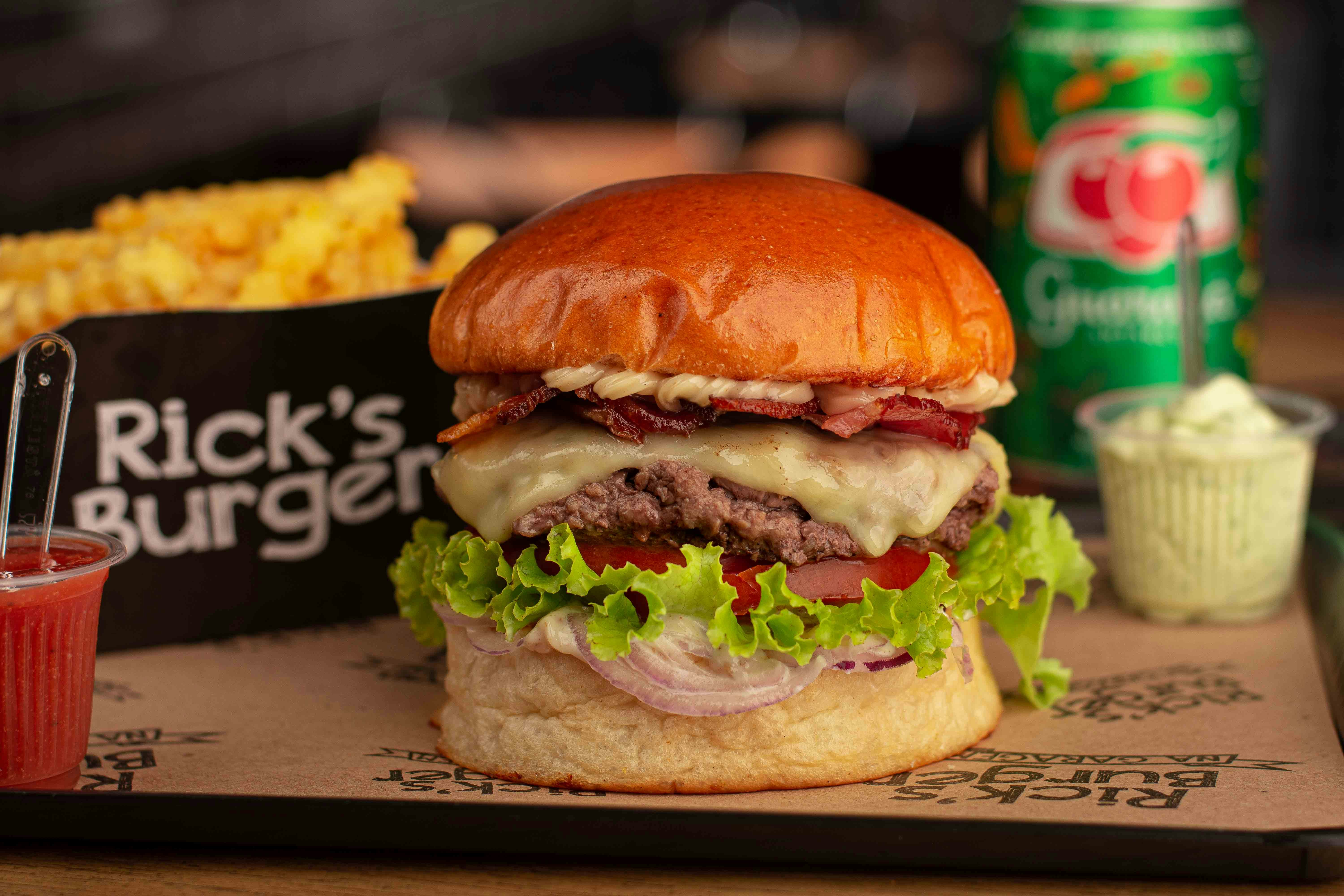 un cheeseburger con un contorno di patatine fritte e una bevanda