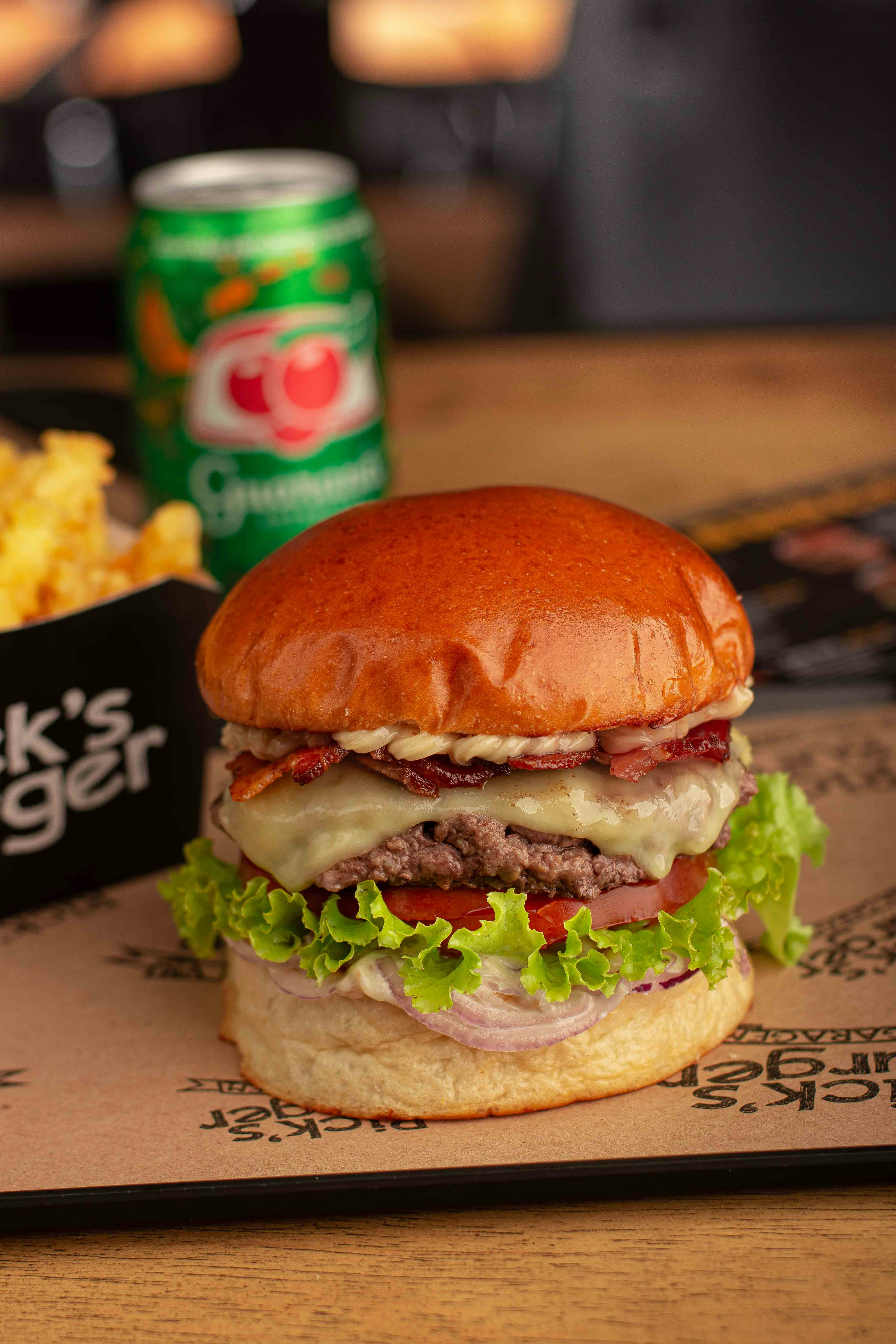 un cheeseburger con un lato di patatine fritte e una lattina di soda