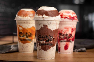 three cups of ice cream sitting on top of a table
