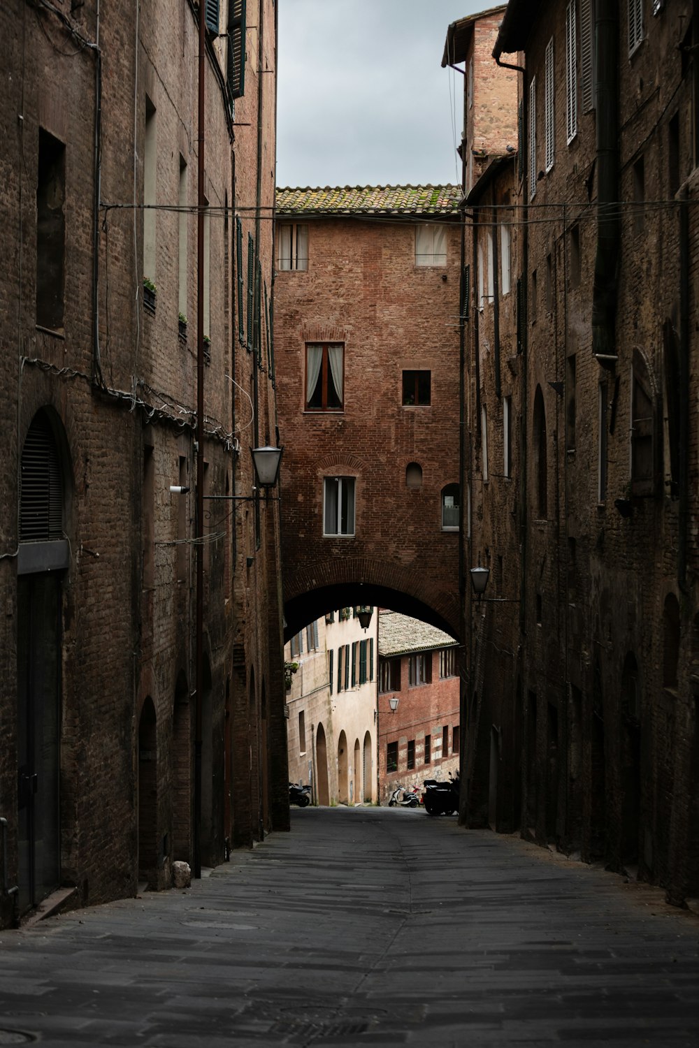 a narrow alley way with a brick building in the background