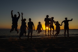 a group of people standing on top of a sandy beach