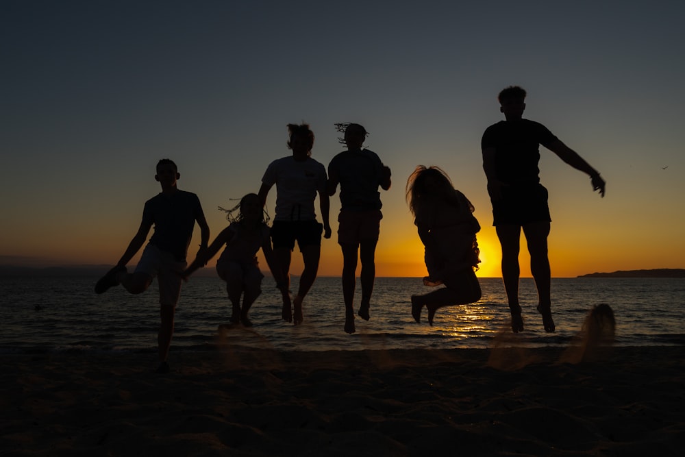 a group of people standing on top of a sandy beach