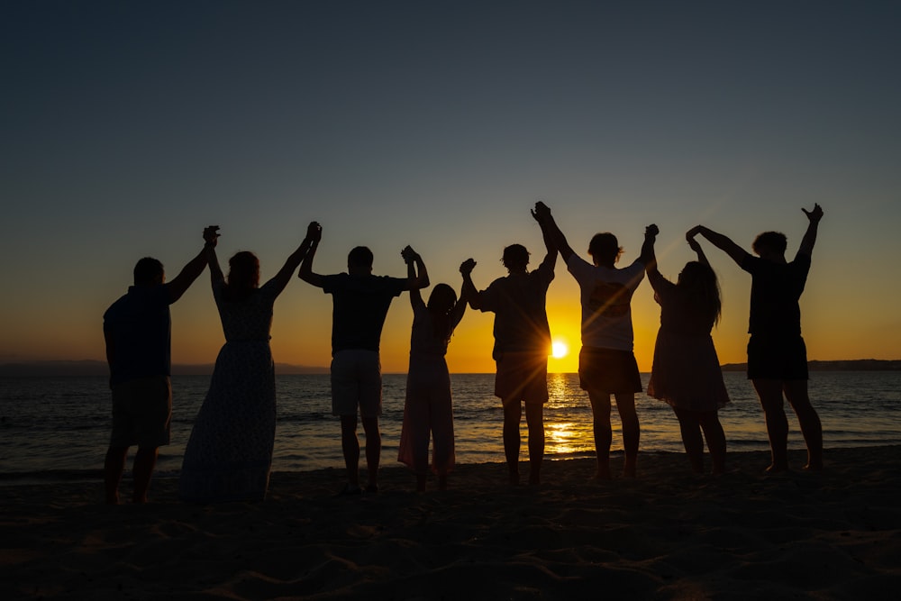 a group of people standing on top of a sandy beach