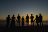 a group of people standing on top of a sandy beach