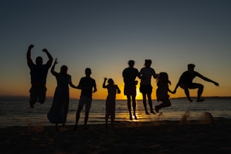a group of people standing on top of a sandy beach