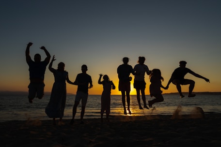 a group of people standing on top of a sandy beach