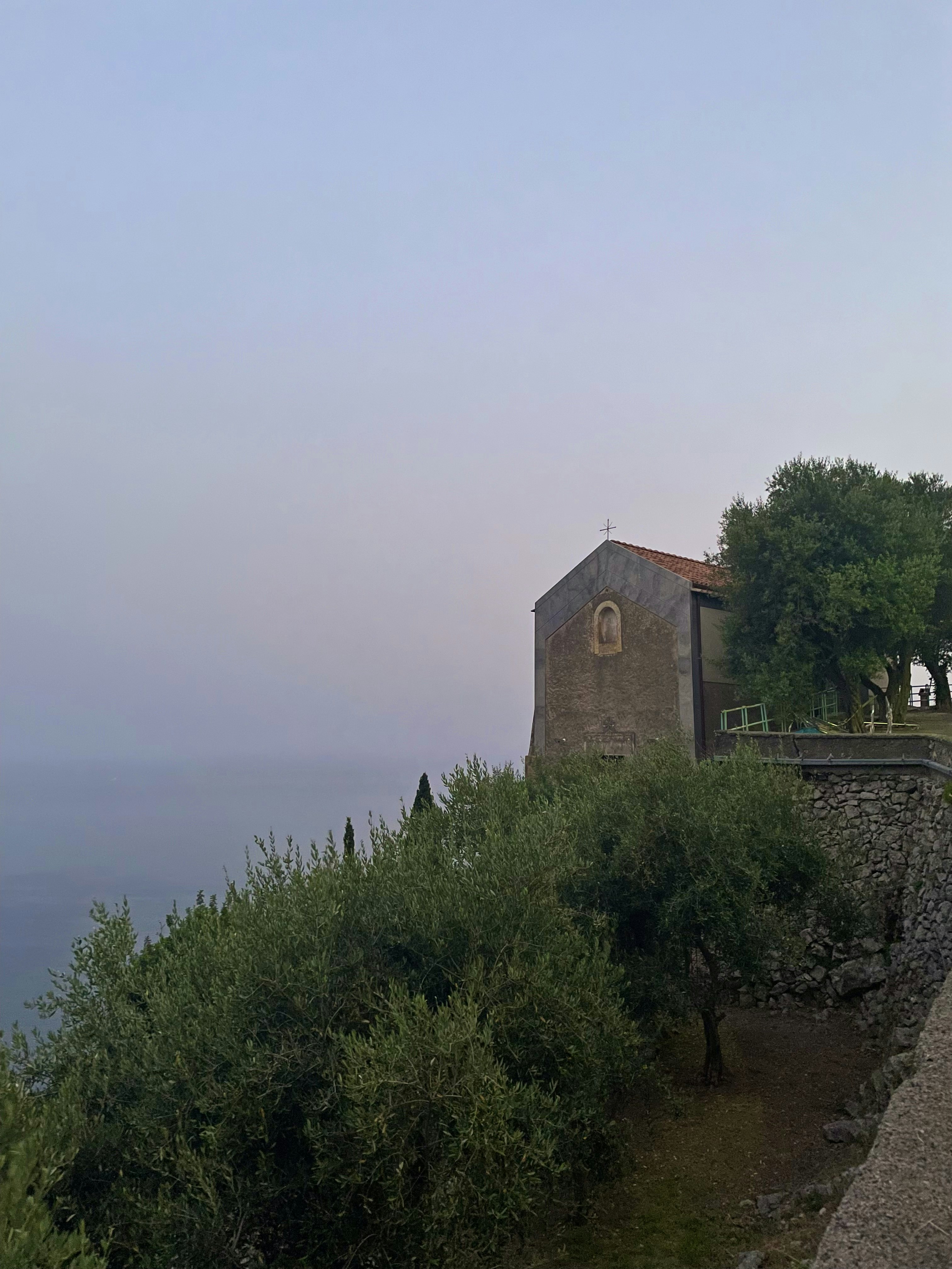 a building on a hill overlooking the ocean
