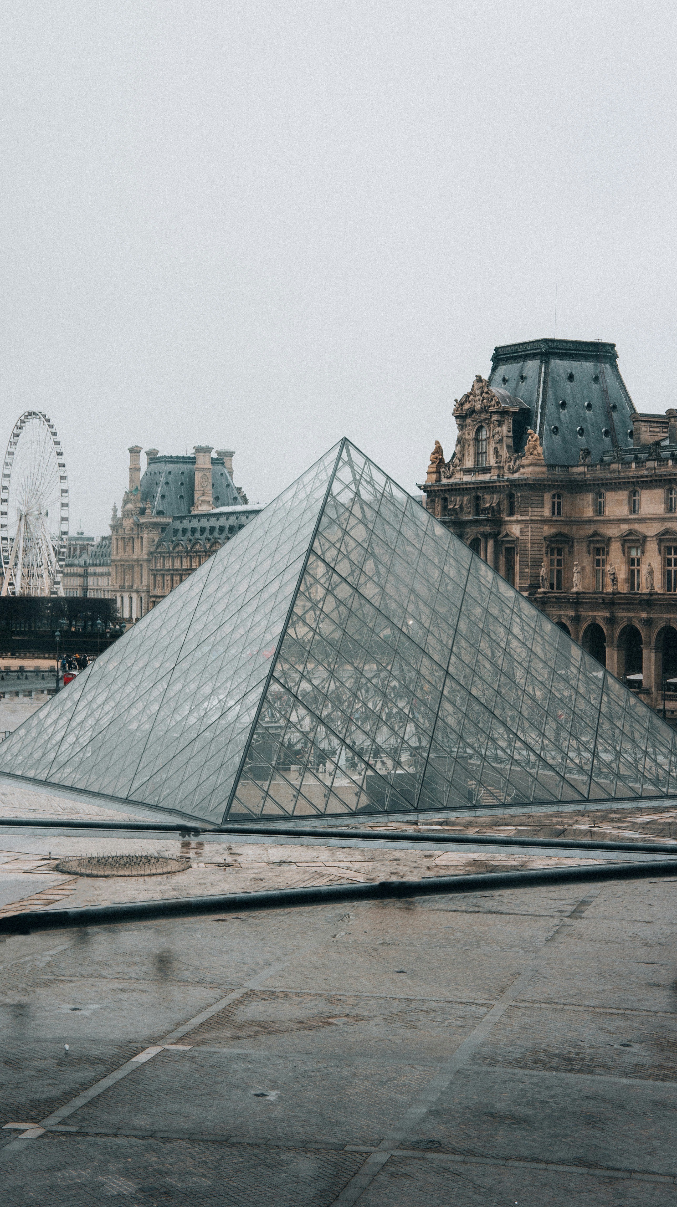 a large glass pyramid sitting in front of a building