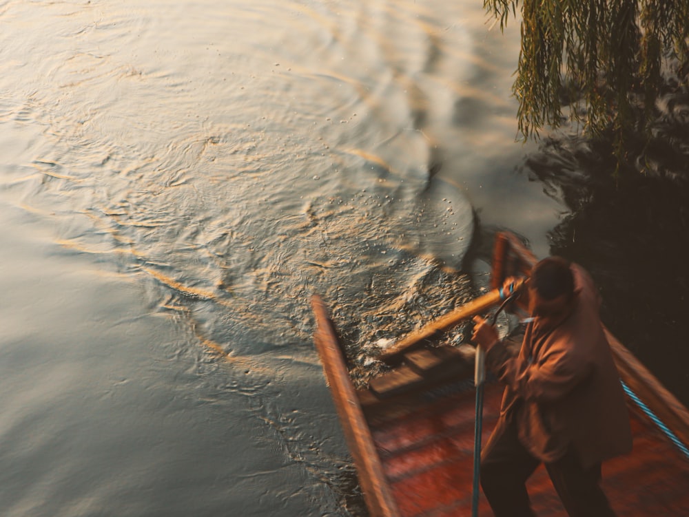 a man standing on a boat in a body of water