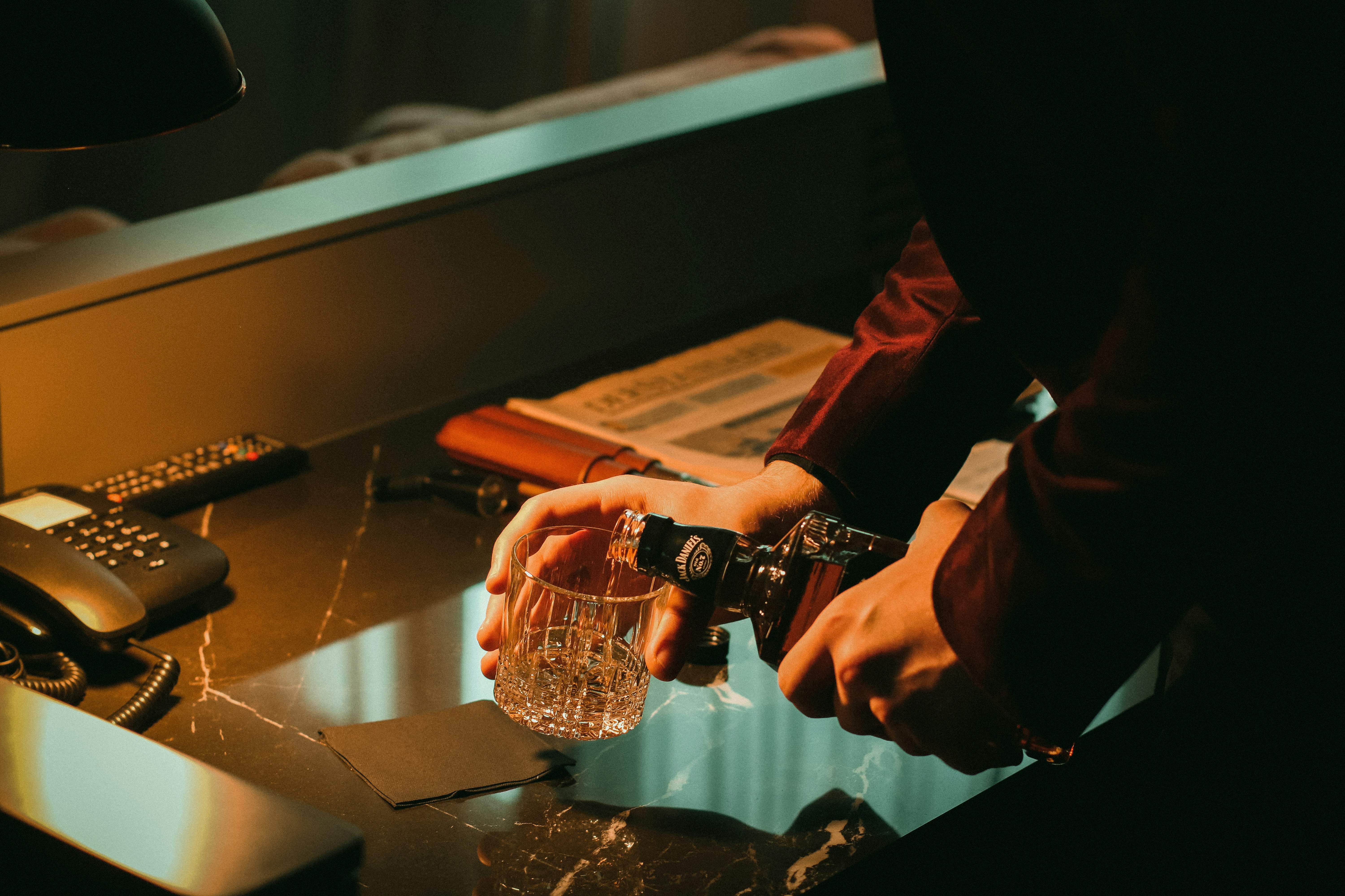 전화기 근처에 물 한 잔을 들고 있는 사람