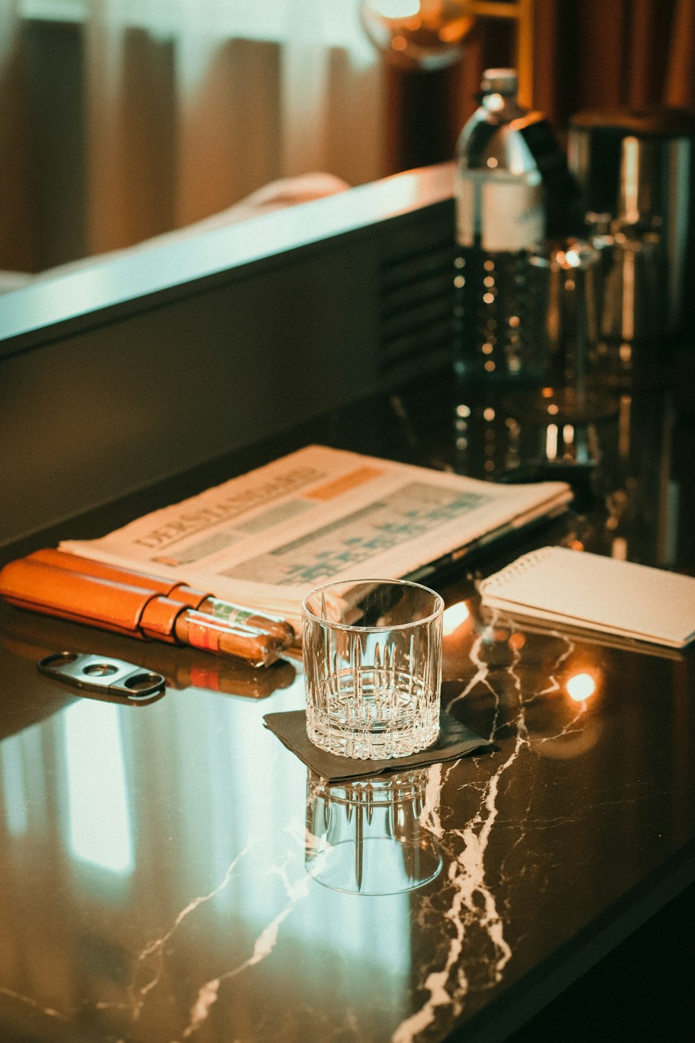 a glass of water and a book on a table