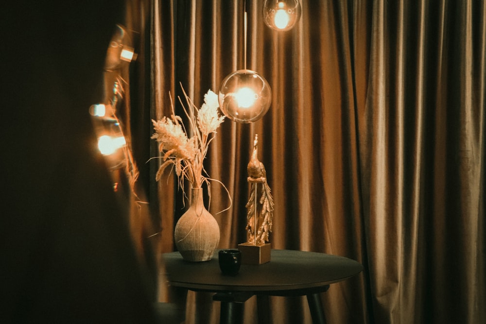 una mesa con un jarrón y algunas luces
