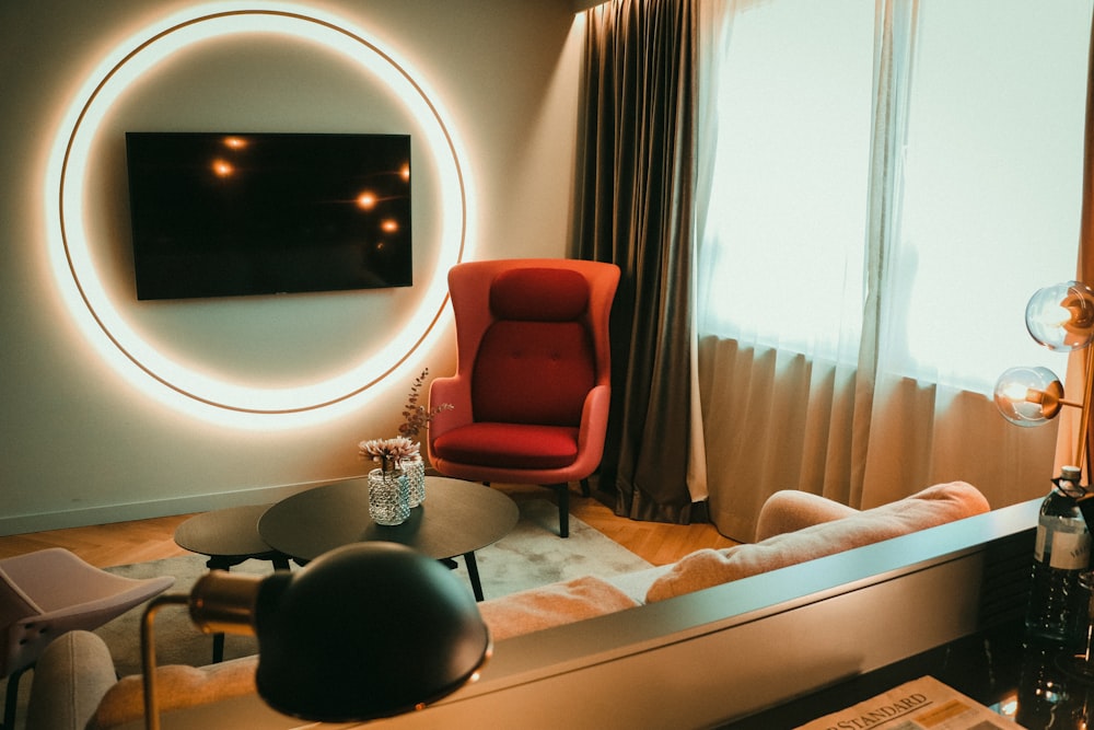 a living room with a red chair and a round mirror