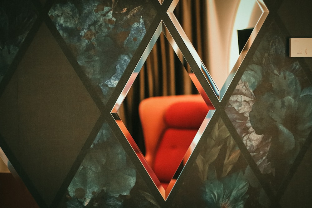 a red chair sitting in front of a mirror