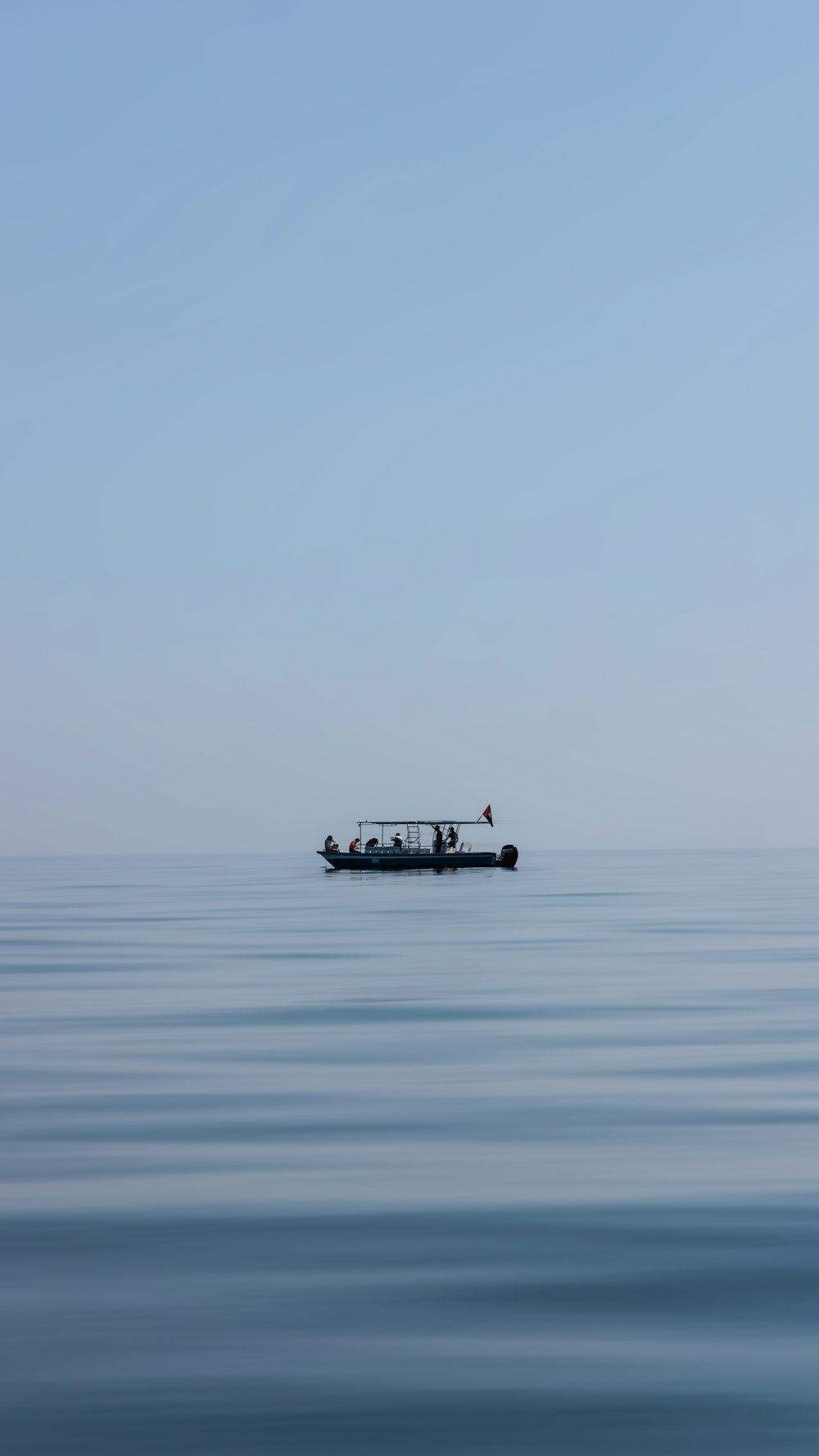 a small boat floating on top of a large body of water