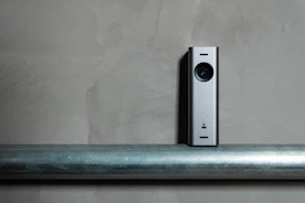 a silver camera sitting on top of a metal pole