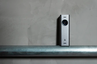 a silver camera sitting on top of a metal pole