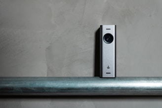 a silver camera sitting on top of a metal pole