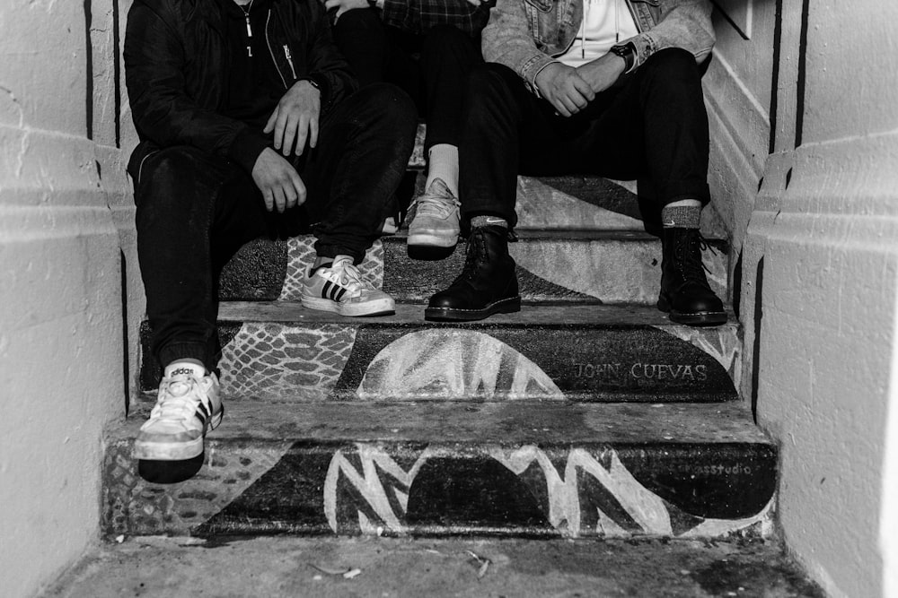 two men sitting on the steps of a building