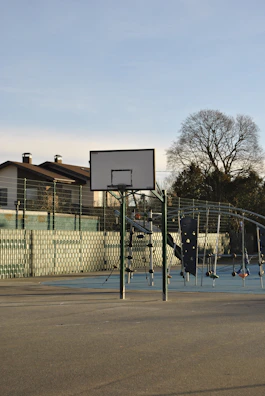 Young players practicing dribbling drills on an outdoor basketball court under clear skies.