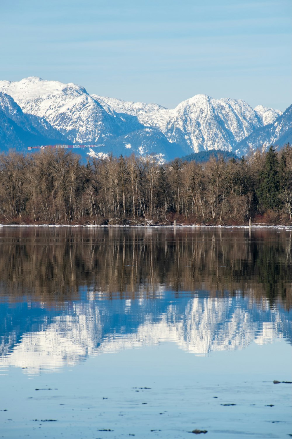 a lake surrounded by snow covered mountains and trees