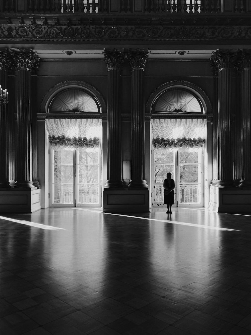 Una foto in bianco e nero di una persona in piedi in una grande stanza