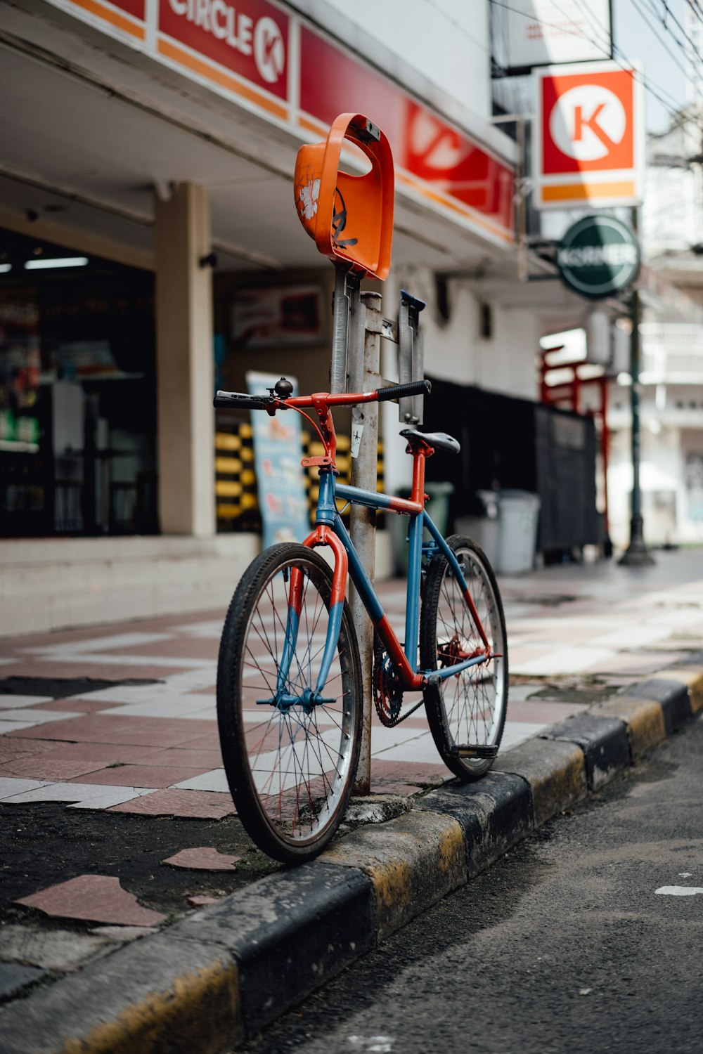 a blue and orange bike parked on the side of a street