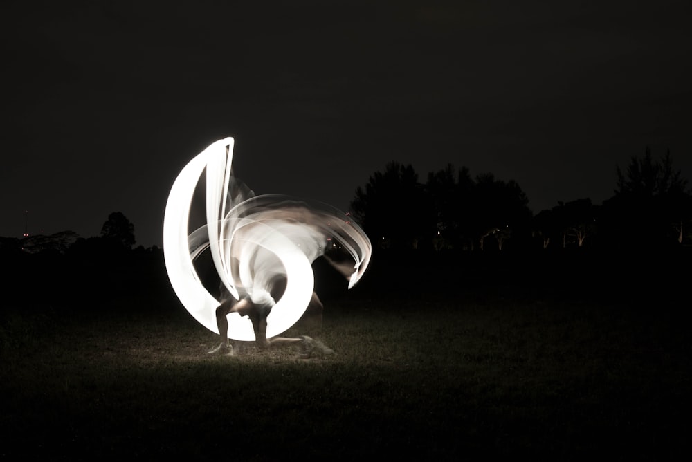 a person standing in a field with a light painting