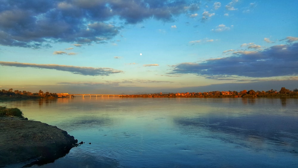 a body of water with a bridge in the background