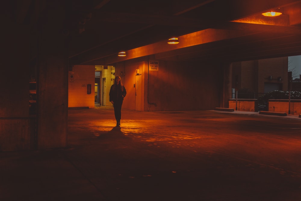 a person standing in an empty parking garage