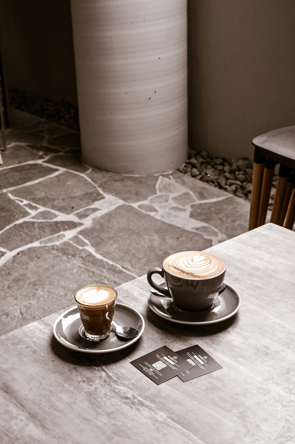 two cups of coffee sitting on top of a table