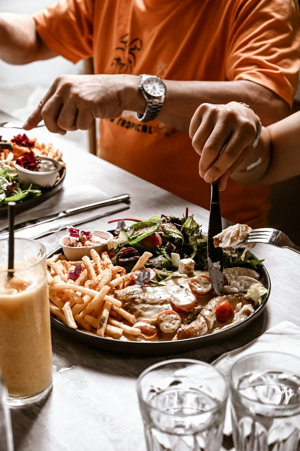 Un homme coupe dans une assiette de nourriture