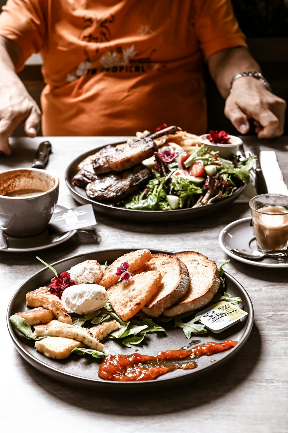 a man sitting at a table with two plates of food